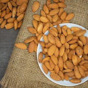 Top view of almonds in a white bowl on a burlap surface, highlighting healthy snacking.